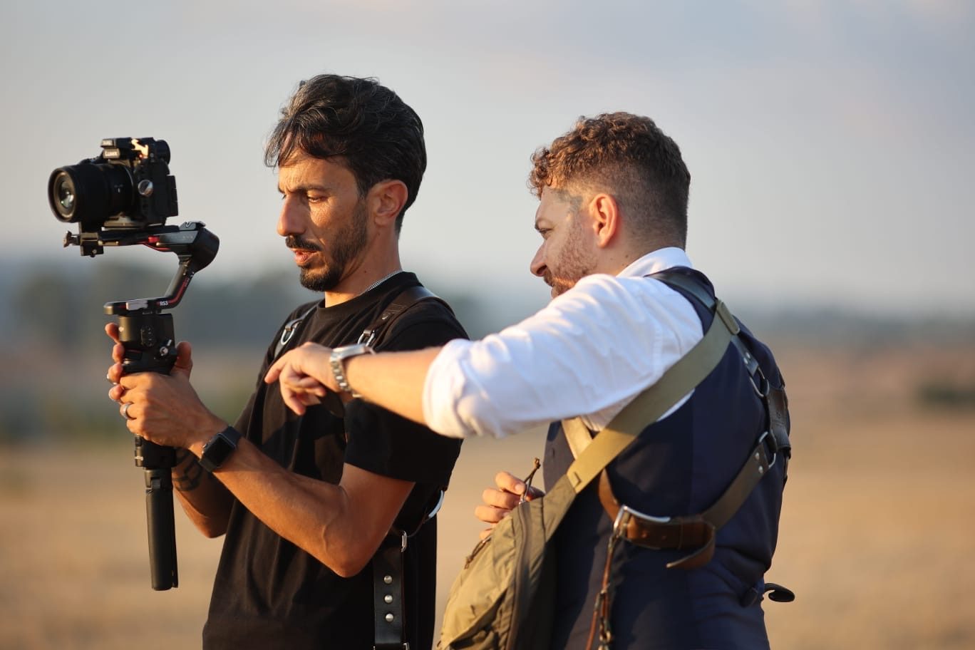 Giuseppe Cimino showing his Lumix settings to his colleague Giuseppe Galat&agrave;, who holds the camera on a gimbal, on location at golden hour