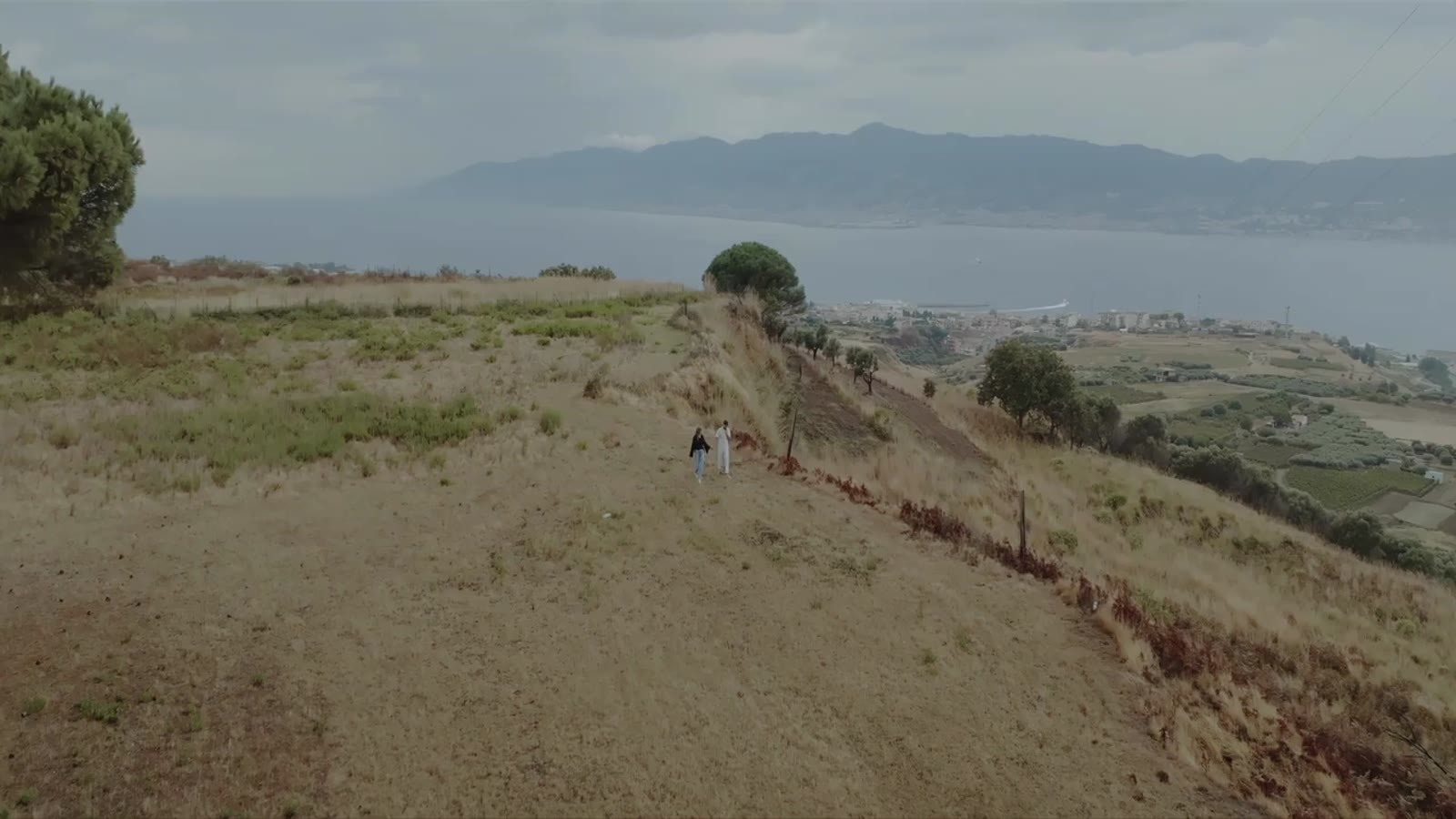 Aerial drone shot of a bride and groom over the Strait of Messina