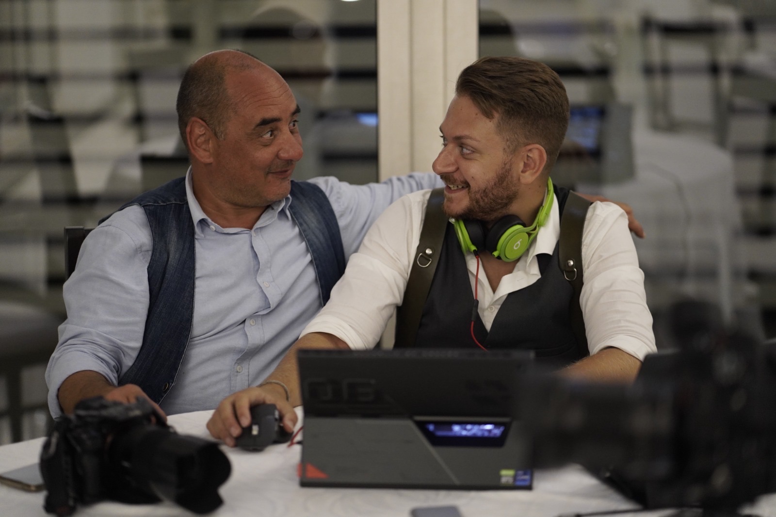Giuseppe Cimino editing a same day edit on a laptop at the wedding venue, next to a colleague