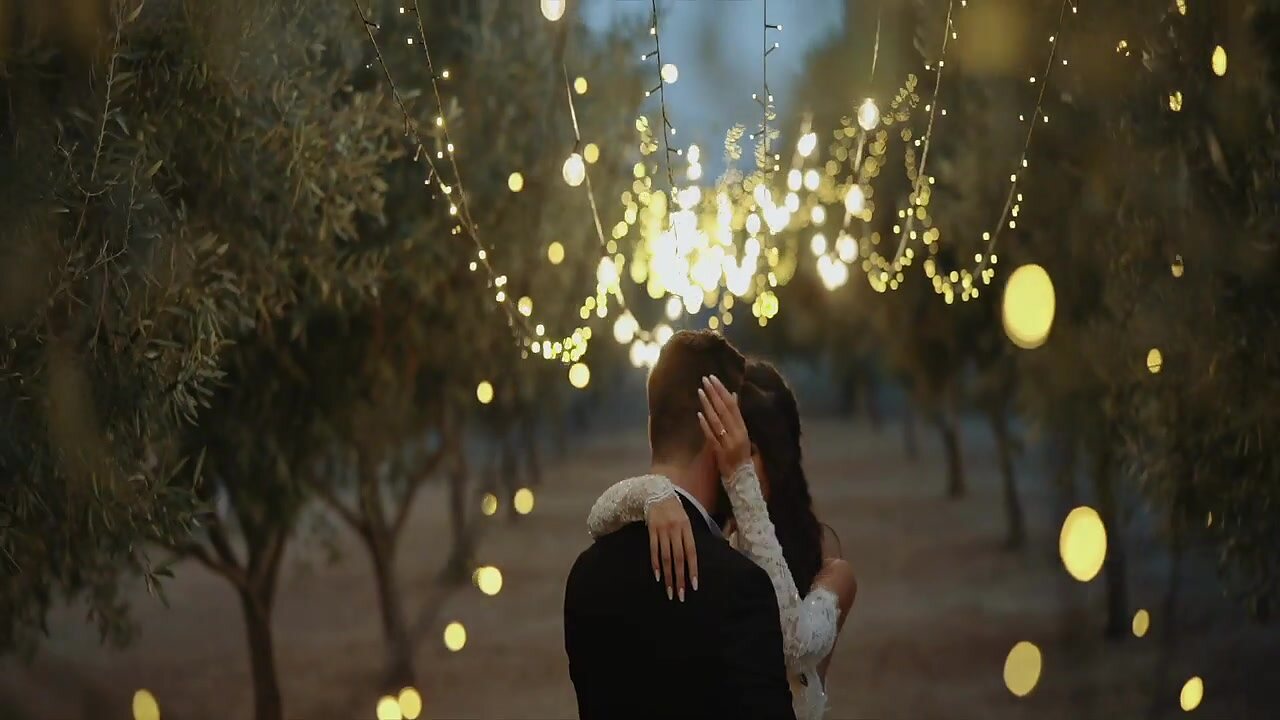 Bride and groom under fairy lights in the evening in Italy